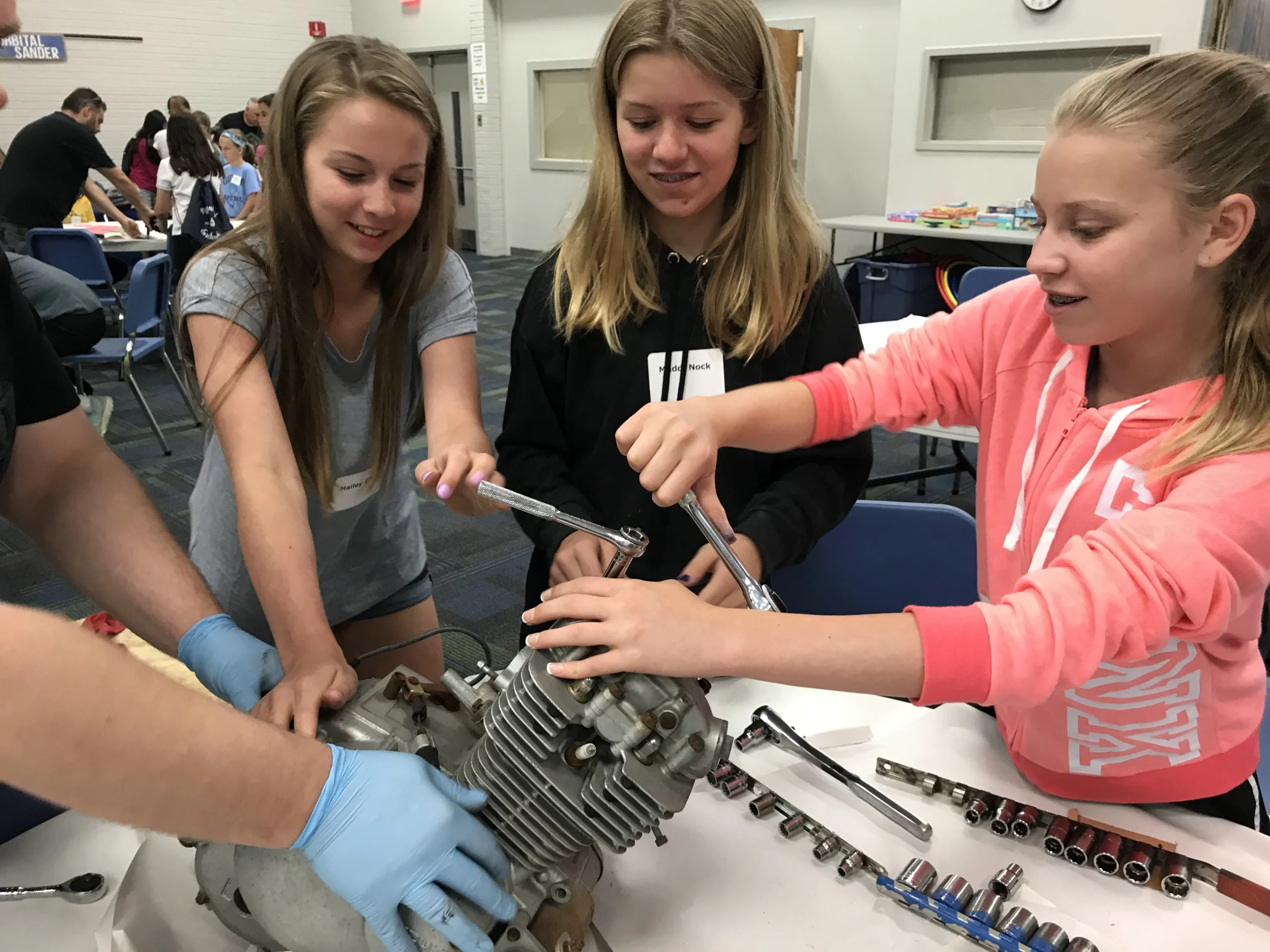 girls taking apart an engine at engineering summer camp